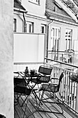 Tisch mit Stühlen auf dem Balkon (s-w-Aufnahme)