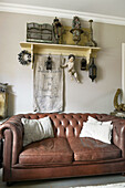 Antique bric-a-brac on shelf above vintage leather couch