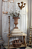 Urn vase in front of old white cupboard