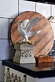 Dove figurine in front of round wooden board