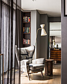 Standard lamp and upholstered armchair in bedroom