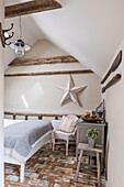 Country-style guest room under a sloping roof with single bed and star decor