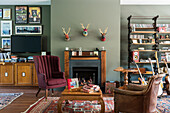 Living room with fireplace, olive green wall and vintage furniture