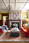 Traditional living room with fireplace, colourful upholstered furniture and patterned carpet