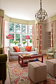 Classic living room with bay window, elegant curtains and beige-coloured sofa