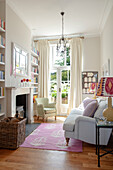 Klassisches Wohnzimmer mit weißem Sofa, Kamin, hohen Decken und bodenlangen Vorhängen
