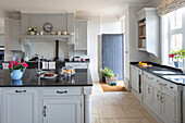Country kitchen in grey with dark worktop and light floor tiles