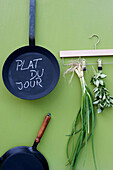 Frying pans and coathanger with herbs
