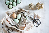 Still life with eggs, newspaper, scissors and paper balls