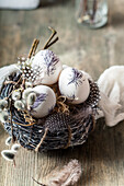 Bemalte Ostereier, Nester, Federn und Weidenkätzchen
