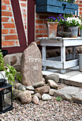 Steindekoration und Holzbank mit Blumentöpfen auf der Terrasse