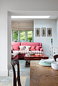 Living room with red corner sofa, wooden table and pictures on the wall