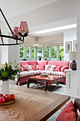 Living room with red sofa, patterned cushions and window wall