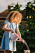 Little girl watering flowers in the garden