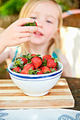Mädchen, das Erdbeerformschüssel isst