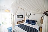 Gemütliches, luftiges Schlafzimmer mit blauen Kissen