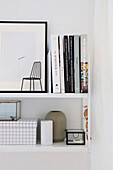 Minimalist, white wall shelf with books and decorative objects