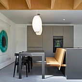 Dining area with custom-made wooden bench in open-plan kitchen