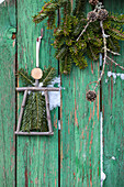DIY guardian angel made of conifer twigs decorating door