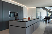 Modern kitchen in black and white with integrated appliances and indirect lighting