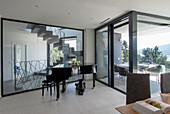 Modern room design with grand piano and designer dining table