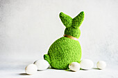 Easter concept with bunny covered with green grass on concrete background