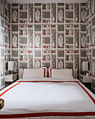 Doppelbett mit roter und weißer Bettwäsche, Trompe L'oeil Tapete an den Wänden