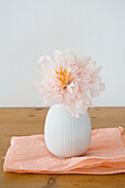 DIY peony in white vase on wooden table