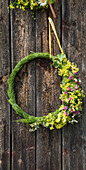 Floral wreath with wildflowers on a wooden wall