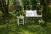 Garden bench with cushions and wooden stool in the countryside