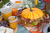 Autumnal table decoration with pumpkin and preserving jars