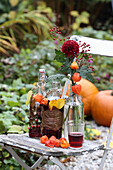 Herbstlich dekorierte Flaschen mit Roteichenlaub und Hypericum und kleiner Herbststrauß