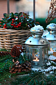 Zinc lanterns with pine cones and teaberries in the snow