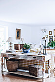Antiker, französischer Tisch hinter Sofa mit kariertem Bezug im Wohnzimmer