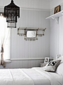 Double bed in white bedroom with wooden panelling