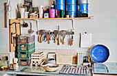 Töpferwerkstatt mit Farbdosen auf einem Regal, verschiedenen Geräten und Pinseln auf einem Tisch