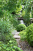 Garden path made of pebbles and pond in the background
