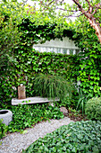 Hidden seating area surrounded by climbing plants in the garden