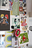 Prints and cards pinned on a studio wall
