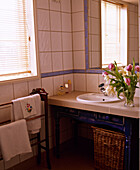 Washbasin set in tiled shelf next to towel rail
