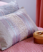 Detail of embroidered beaded cushions and a gingham cloth