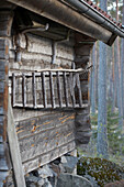 Leiter aus Zweigen an der Außenseite einer Jagdhütte im schwedischen Wald Svartadalen