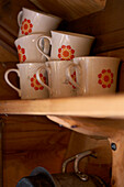 1950s cup set on wood shelving in Svartadalen hunting cabin, Sweden