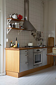 Küchenzeile mit integriertem Backofen und Dunstabzugshaube aus Edelstahl in einer Stockholmer Wohnung aus dem 20. Jh.