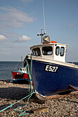 Blaues Fischerboot am Kiesstrand in Devon
