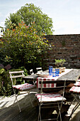Table and folding chairs in walled garden Rye, Sussex
