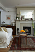 White sofa and patterned rug with fireplace in Arundel reception room, West Sussex