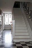 Schwarz-weiß gefliester Boden und gestrichene Treppe