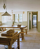 Country style kitchen with stone floor and rustic wooden tables