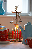 Christmas decoration and cups with teapot on table